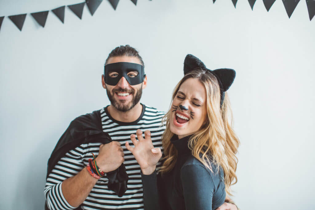 A couple is pictured, with the man wearing a burglar costume and the woman wearing a cat costume.