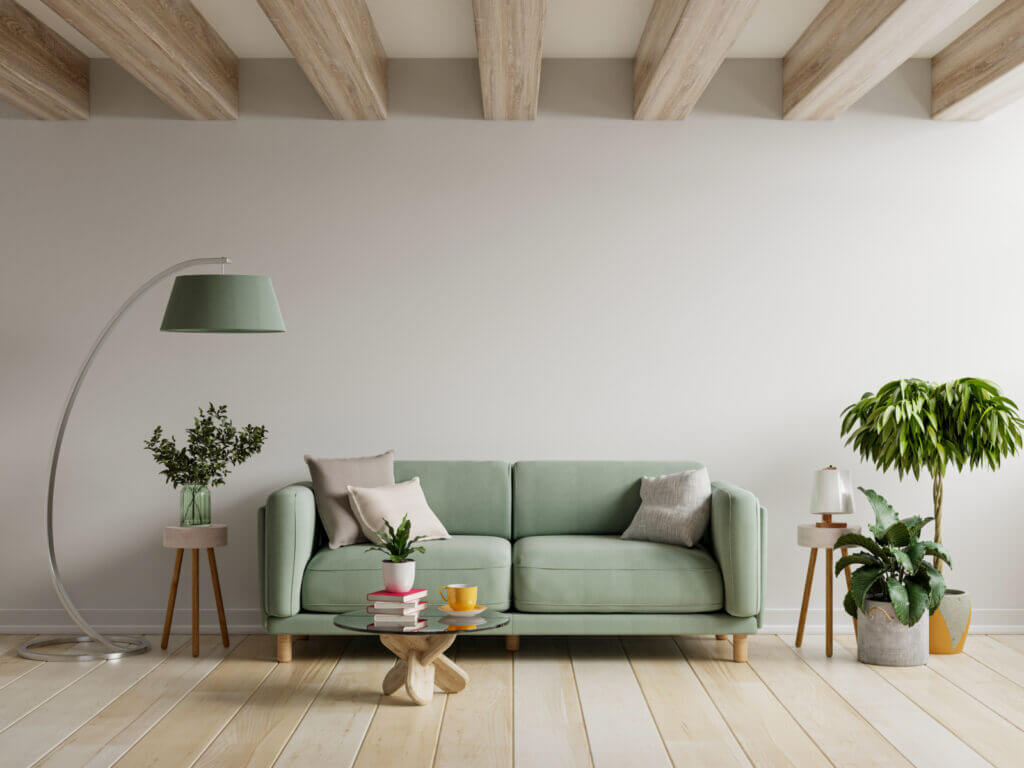 A room is shown with soft wood tones, a taupe wall, and soft green furniture to create a mellow, relaxing feel.