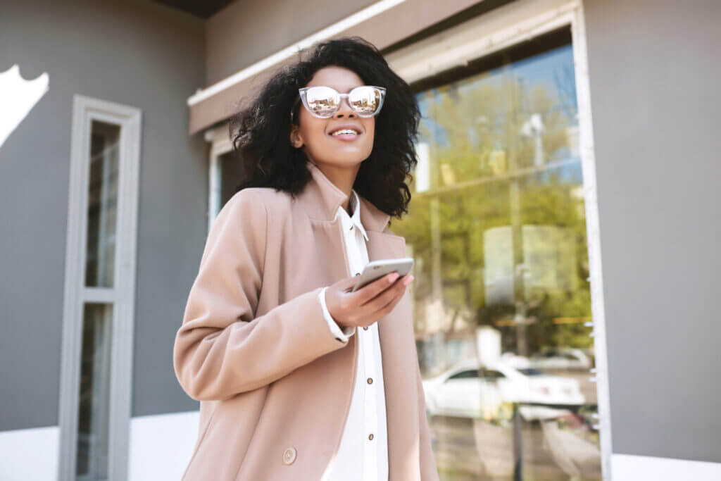 A woman is pictured wearing a formal yet modern jacket in an elegant taupe color.