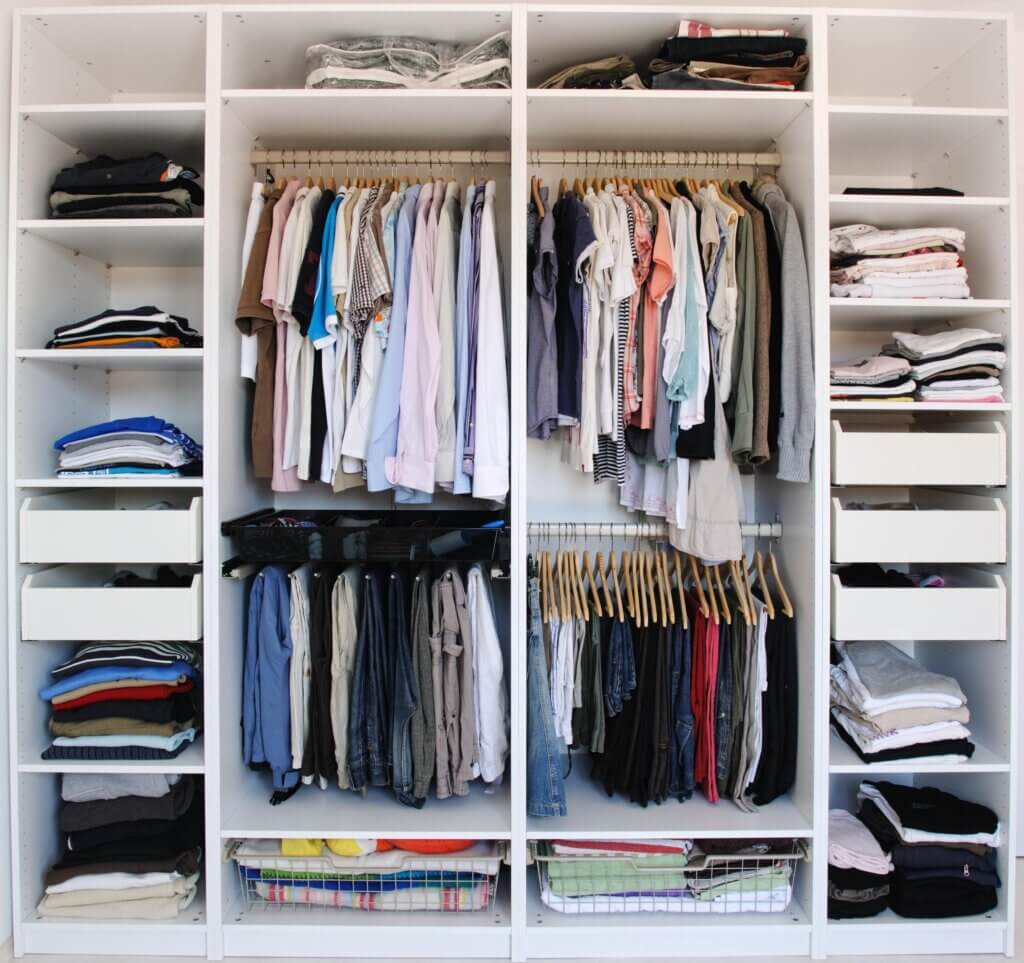 A picture of a well-organized closet, with plenty of shelves, drawers and racks for storage.
